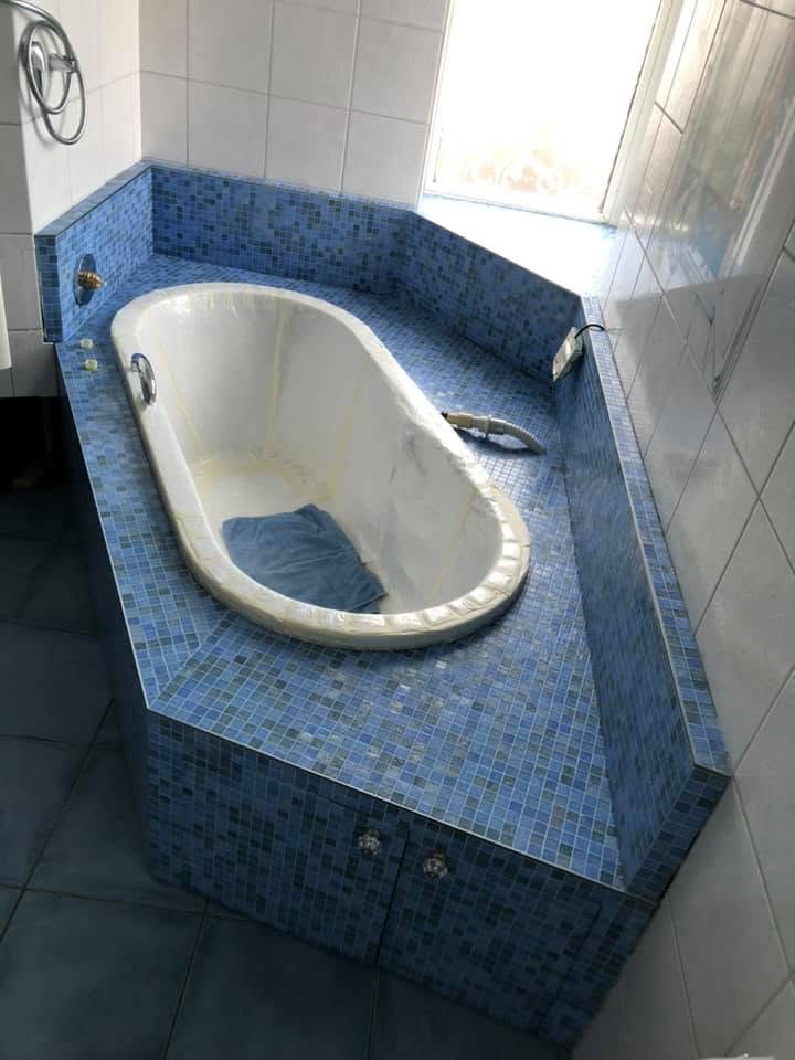 Eckbadewanne mit blauem Glasmosaik